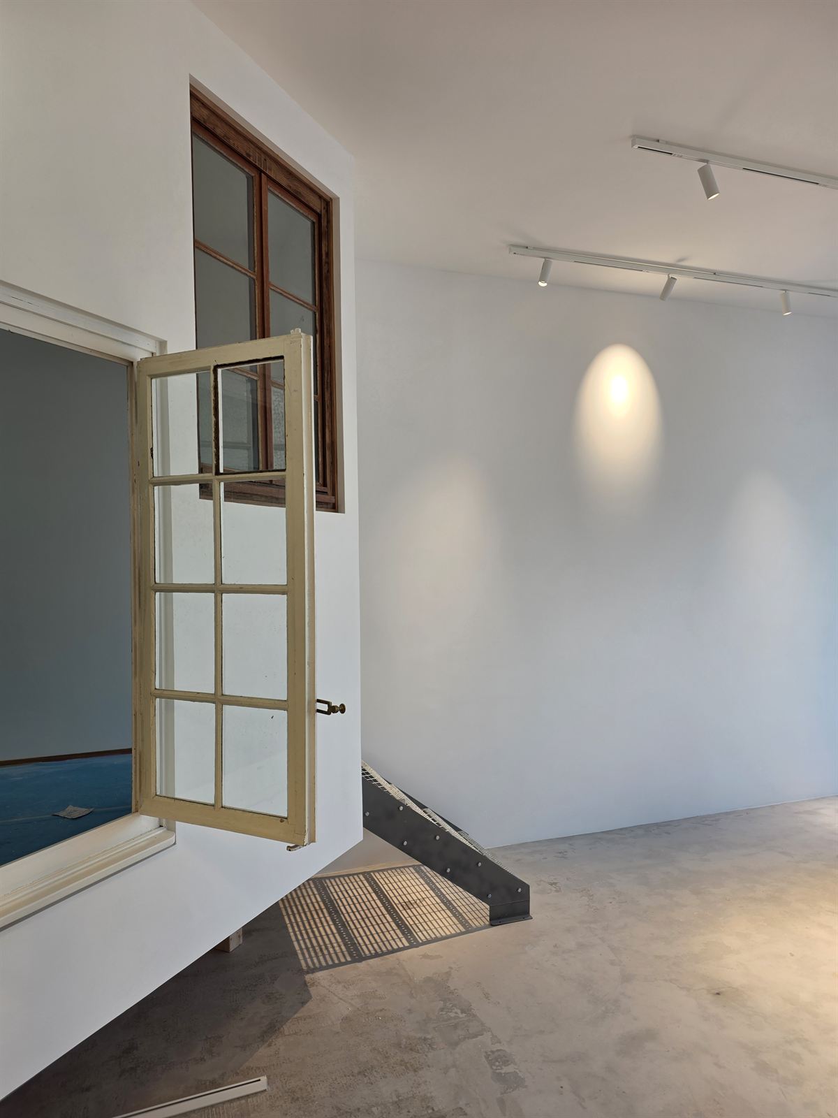 Mur blanc avec verrière intégrée et rampe d'éclairage